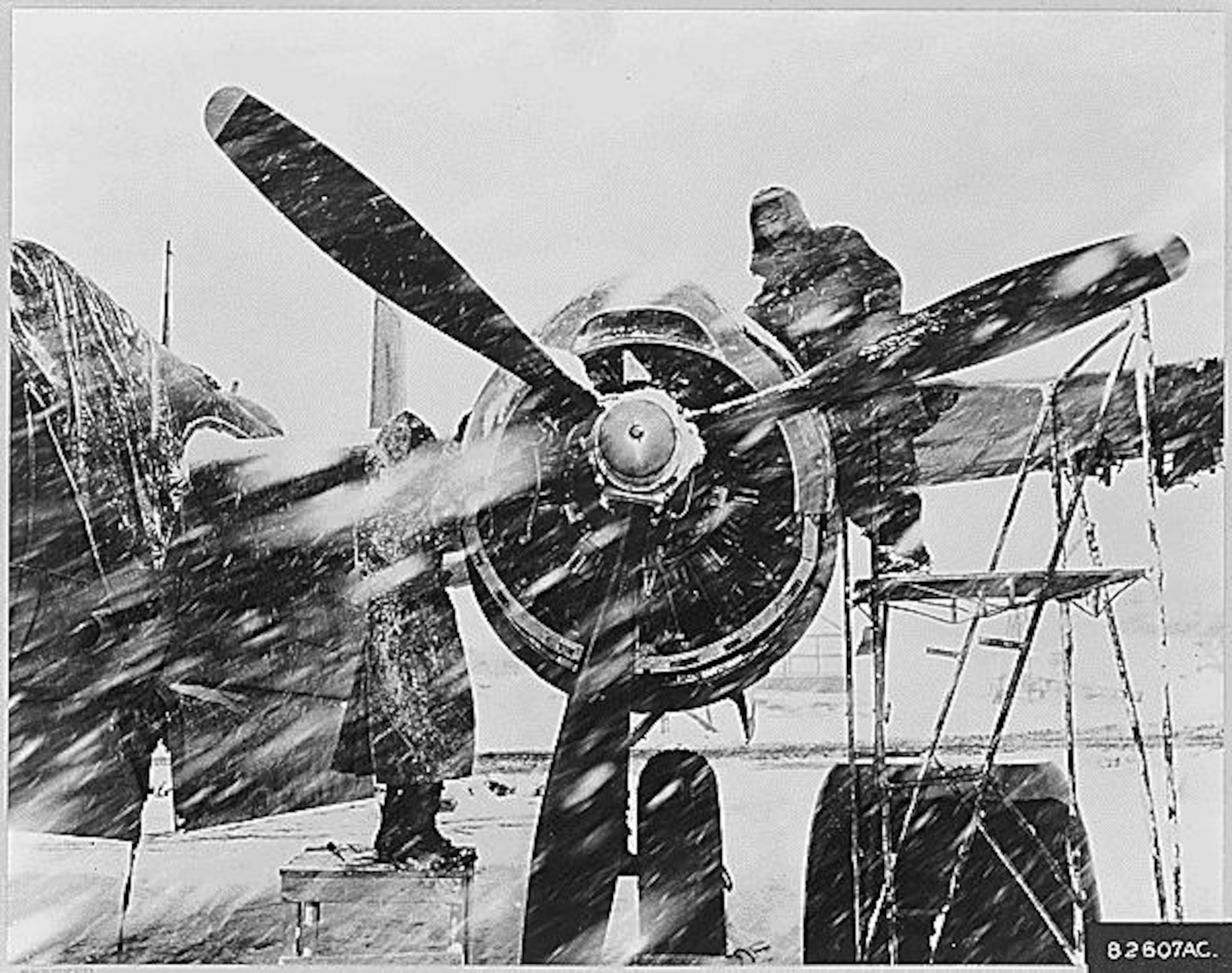 THE NATIONAL ARCHIVES - Ignoring a Korean snow storm, two ground crew memebers of the 3rd Bomb Wing work on an engine of a U.S. Air Force B-26 Night Intruder. These light bombers, carrying out "Operation Strangle," hit Communist troop supply lines every night in all kinds of weather. Armed with tons of bombs and ammunition, attacking visually or by radar, the twin engined B-26s have taken a heavy toll of enemy rolling stock since the 3rd Bomb Wing entered the war in June 1950., ca. 01/1952