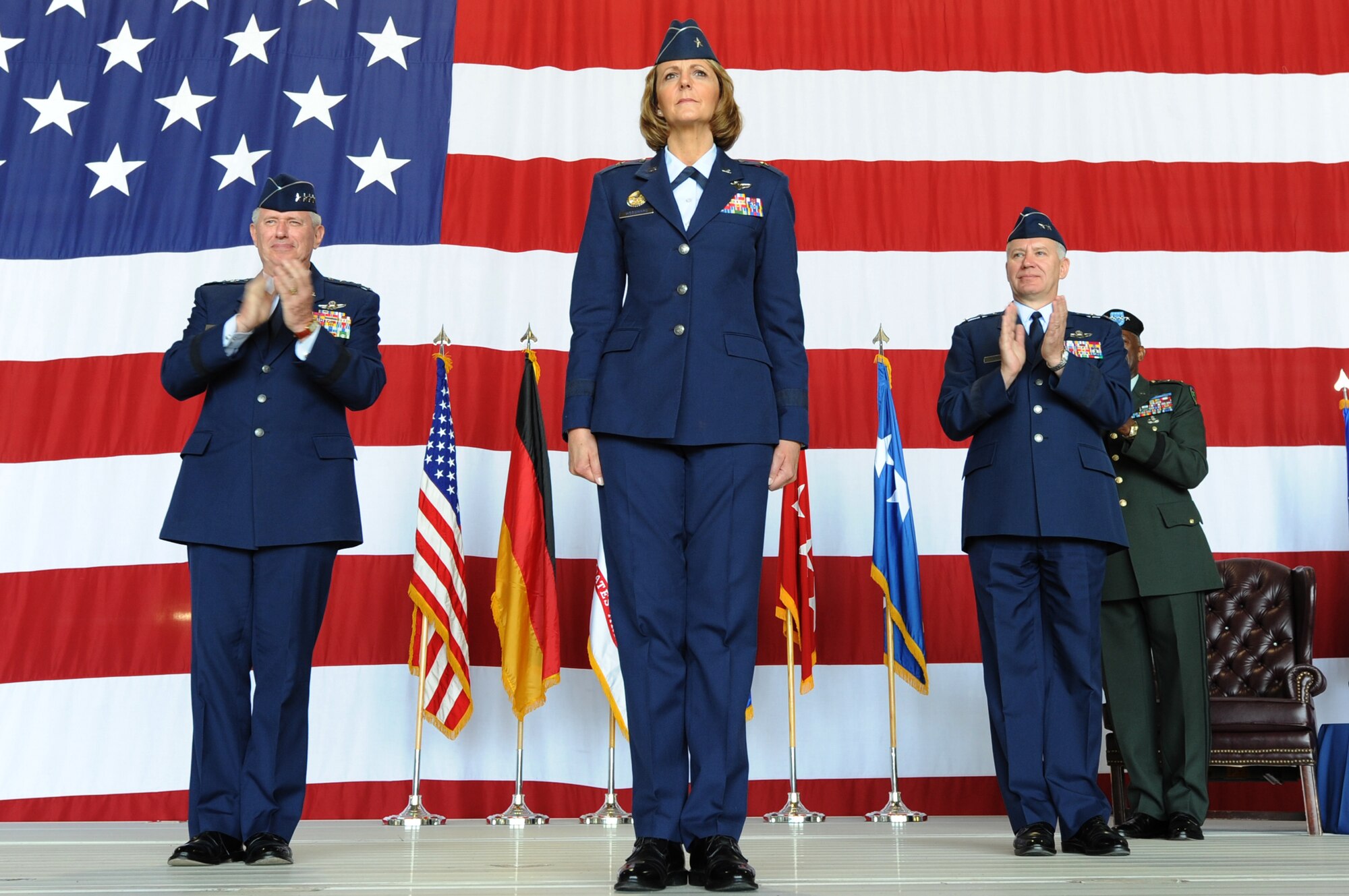 RAMSTEIN AIR BASE, Germany -- New 17th Air Force Commander Brig. Gen. Margaret H. Woodward (center) receives applause from USAFE Commander Gen. Roger A. Brady (left) and former 17 AF Commander retired Maj. Gen. Ron Ladnier June 28 during a change of command ceremony here. (U.S. Air Force photo by Airman 1st Class Brea Miller) 