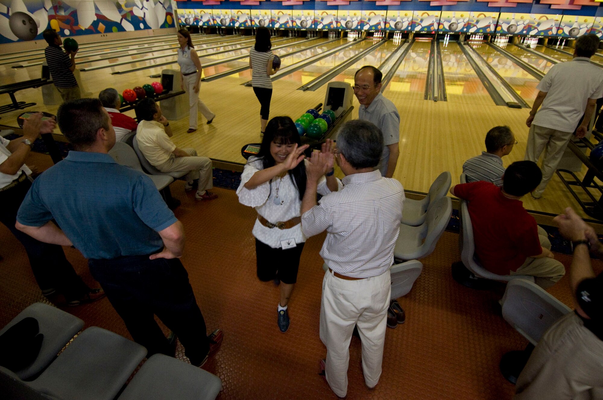 After bowling a strike, Daisy Haugen, wife of Navy Capt. James Haugen, Naval Air Facility Misawa commanding officer, celebrates with Misawa City Officials, June 26, during a friendship bowling tournament at the Walmsley Bowling Center. The 14 teams each had at least one member from the 35th Fighter Wing community, JASDF leadership and Misawa City officials.  Mrs. Haugen received the highest individual score, 199, at the event. (U.S. Air Force photo/Senior Airman Jessica Lockoski)