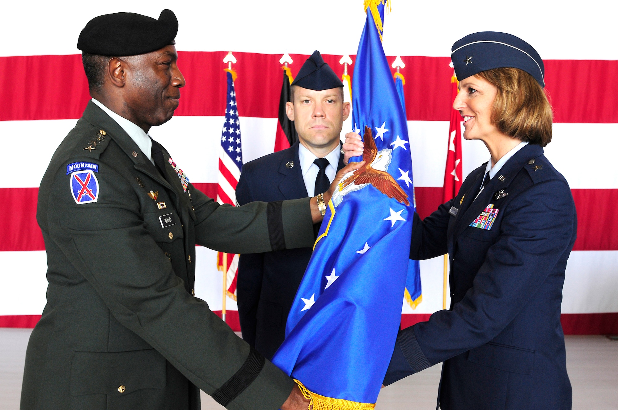 RAMSTEIN AIR BASE, Germany -- Army Gen. William E. "Kip" Ward (left), commander of U.S. Africa Command, passes the 17th Air Force (Air Forces Africa) guidon to Brig, Gen. Margaret H. Woodward during a change of command ceremony here June 28. 
AFAFRICA Command Chief Master Sgt. Michael Grimm looks on. 
Both General Ward and USAFE Commander Gen. Roger A. Brady transferred authority for the command, which serves as the air component to U.S. Africa Command, to General Woodward. (U.S. Air Force photo by Airman 1st Class Brea Miller)
