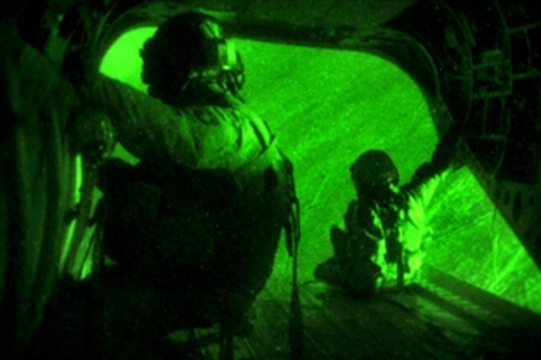 U.S. Army CH-47 Chinook helcopter door gunners survey the ground during a night flight in southern Afghanistan, June 26, 2010. The soldiers are assigned to the 101st Combat Aviation Brigade.