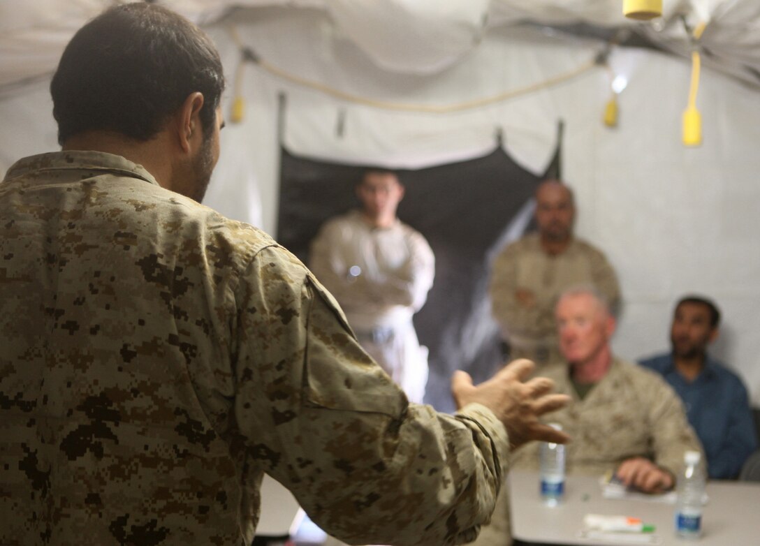 A Pashto linguist speaks to Regional Command Southwest commander Maj. Gen. Richard P. Mills, during a security conference at Forward Operating Base Sher Wali, Marjah, Helmand province, Afghanistan, June 29, 2010. The meeting was held to discuss the emergence of the Afghan Uniform Police in Marjah, which is slated to replace the Afghan National Civil Order Police as the area’s local police force in the near future. Attending the event were Mills; Helmand provincial governor, Mohammad Gulab Mangal; Marjah’s district governor, Haji Zahir and other high-ranking Marine, ANCOP and Afghan National Army officers.
