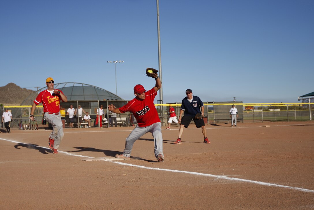 Marvin Barber, a first baseman for the Blue team, makes a catch June 30 at the Combat Center's Felix Field during the Commanding General's Intramural Softball League All-Star game. They played two games and a tiebreaker, ending in a White team victory.