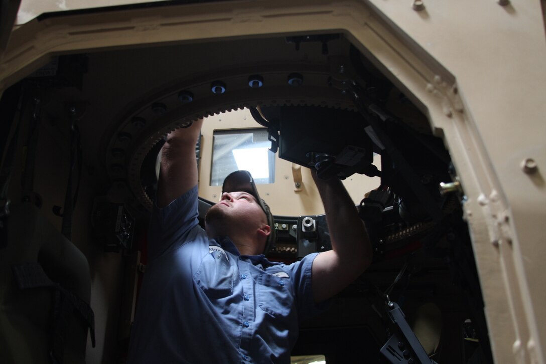 Kyle Matthews, a civilian motor technician mechanic with the Exercise Support Division, tests the turret of an MRAP All-terrain vehicle, Wednesday in an ESD garage. The civilian to Marine ratio is about 19-5.