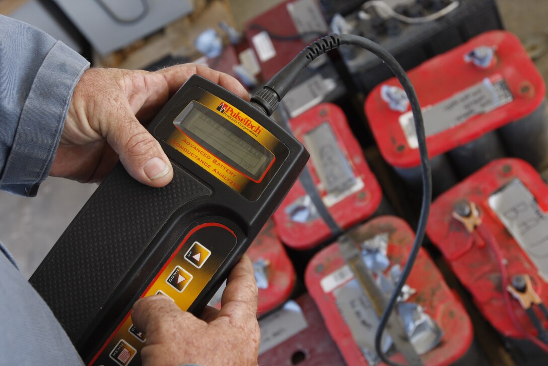 John Vigar, a hazardous material identifier with the Combat Center's Hazardous Material Management Branch, inspects a battery's charging status Tuesday at the branch's area of operations here. Vigar is one of 11 on staff who manage the installation's hazardous waste.