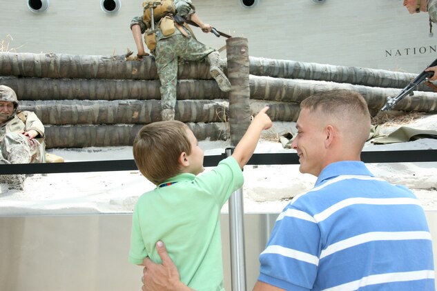 Sgt. Derrick A. Williams shows his 3-year old son, Jaicob, a display at the National Museum of the Marine Corps during a field trip with his unit, Marine Tactical Electronic Warfare Squadron 4, June 29. VMAQ-4 also went to Arlington, Va., to see the silent drill team and the commandant’s own U.S. Drum and Bugle Corps perform in front of the Iwo Jima Memorial. Williams is an electronic countermeasures systems technician.