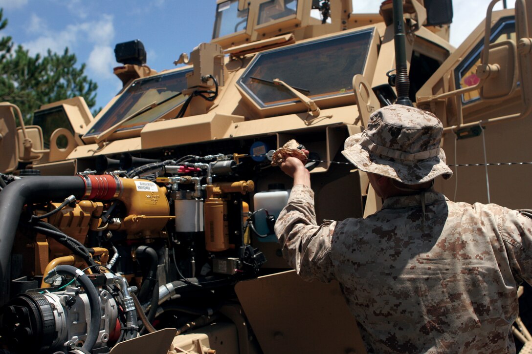 Pfc. Jose Loredo, a motor transportation operator with Truck Company, Headquarters and Service Battalion, 3rd Marine Division, III Marine Expeditionary Force, checks the oil of a Mine Resistant Ambush Protected All Terrain Vehicle after arriving at Landing Zone Mallard in the Central Training Area, June 29.