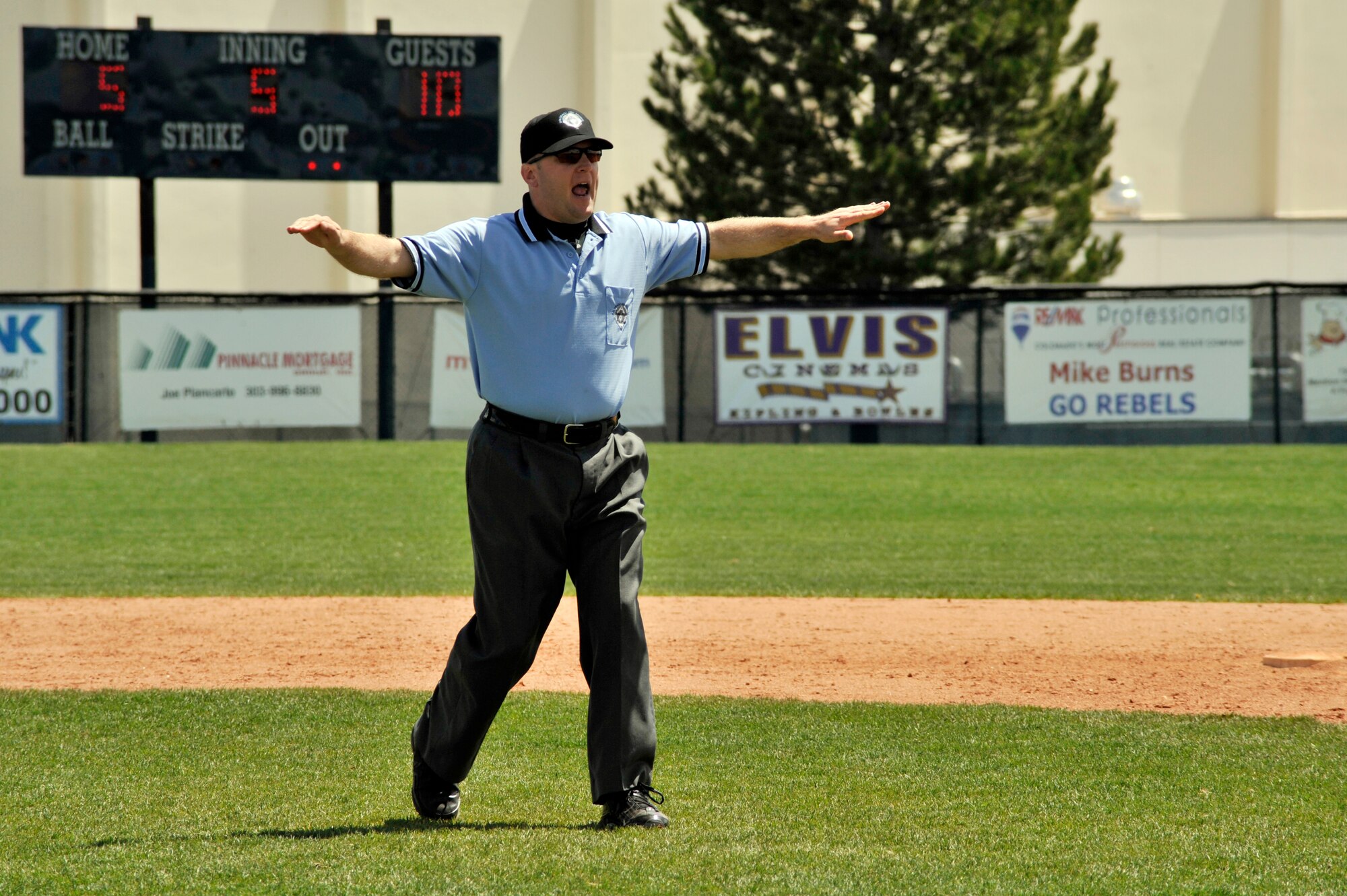 COLUMBINE, Colo. -- Staff Sgt. Larry Bouchard, Air Force Intelligence, Surveillance, and Reconnaissance Agency Detachment 45 Satellite Operations non-commissioned officer-in-charge, gives the "safe" signal during a local high school varsity baseball game May 1. Sergeant Bouchard is certified through the National Federation of State High School Associations and has been umpiring for the last four years. (U.S. Air Force photo by Staff Sgt. Kathrine McDowell)

