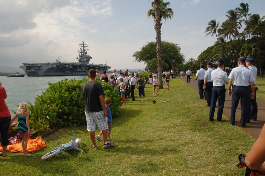 Spectators watch in awe as they welcome the USS Reagan, a U.S. Navy aircraft carrier, as it approaches Joint Base Pearl Harbor Hickam, Hi. June 29 to participate in the 2010 "Rim of the Pacific" exercise. RIMPAC is the world's largest maritime exercise held biennially in June and July in Honolulu, Hawaii under the leadership of United States Pacific Command. (U.S. Air Force photo by Staff Sgt. Nathan Allen)