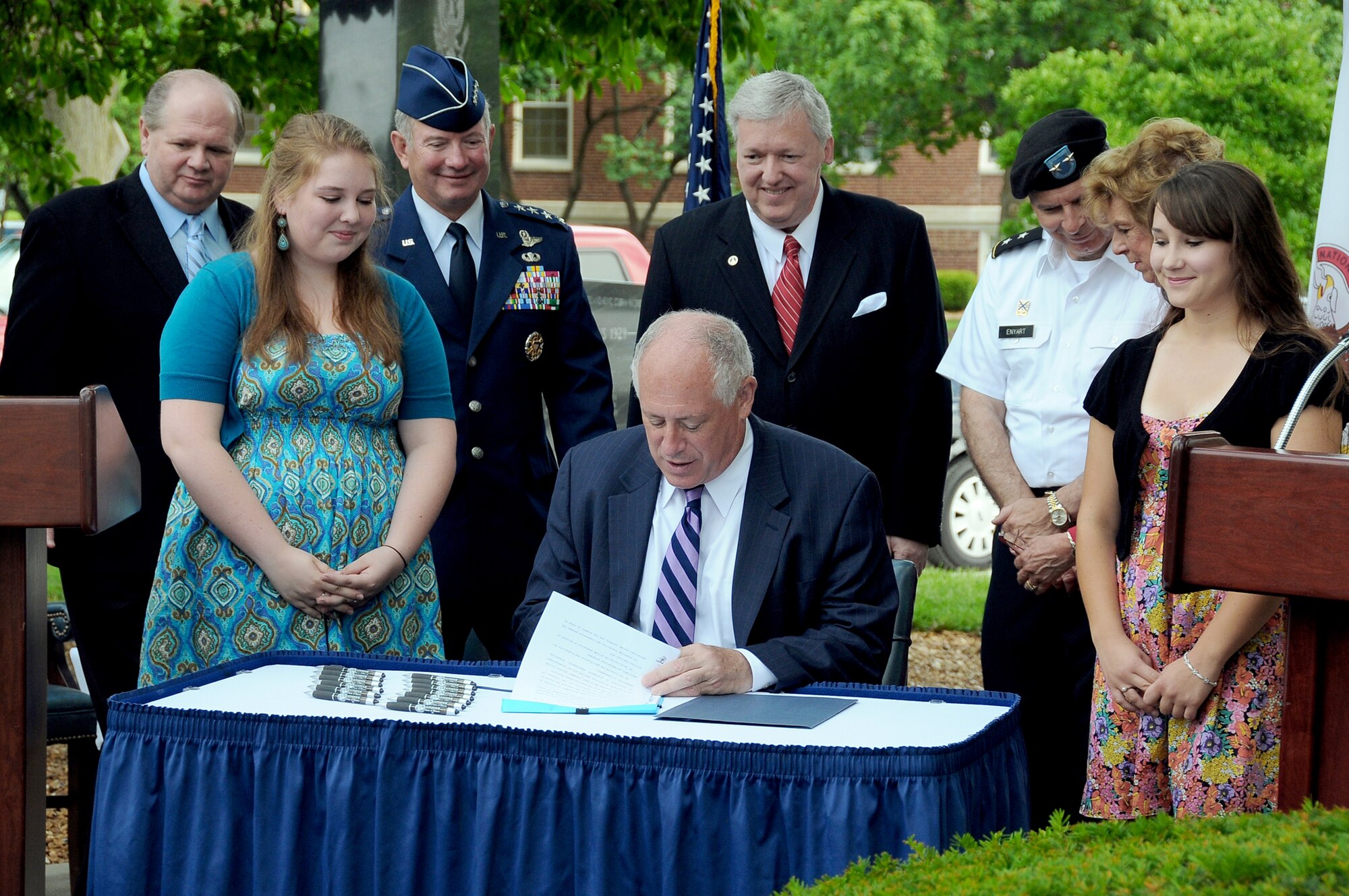 Illinois Gov. Pat Quinn signs the Intestate Compact on Education Opportunity for Military Children into law June 28, 2010, at Scott Air Force Base, Ill. Witnessing the signature are Illinois State Rep. Thomas Holbrook, family member Claire Krebs, commander of U.S. Transportation Command Gen. Duncan J. McNabb, Senior State Liaison for the Department of Defense Thomas Hinton, Adjutant General of the Illinois National Guard Maj. Gen. William Enyart, State Sen. Deanna Demuzio and family member Breanna Bence. (U.S. Transportation Command photo/Bob Fehringer)