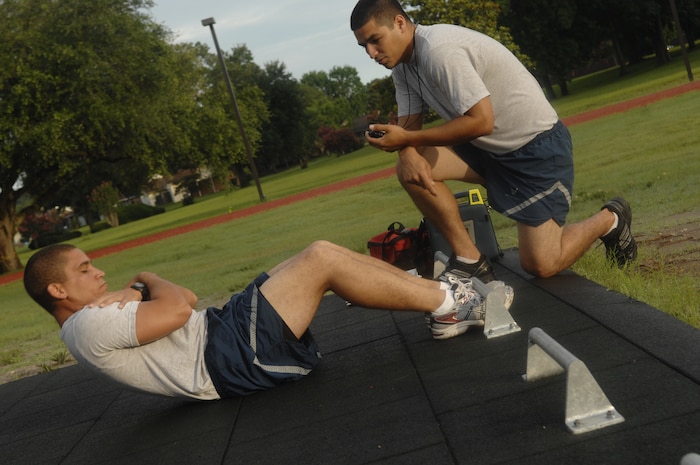 Staff Sgt. Joan Luyando performs sit-ups during his bi-annual physical fitness test at the base running track June 29, 2010 on Joint Base Charleston, S.C. With the new standards, the run counts for 60 percent of the test, while body composition counts for 20 percent, followed by push-ups and sit-ups at 10 percent each. Under the old standards the run counted for 50 percent, the body composition counted for 30 percent, with the push-ups and sit-ups remaining the same. Sergeant Luyando is a quality assurance team member with the 437th Maintenance Group. (U.S. Air Force photo/Senior Airman Timothy Taylor)

