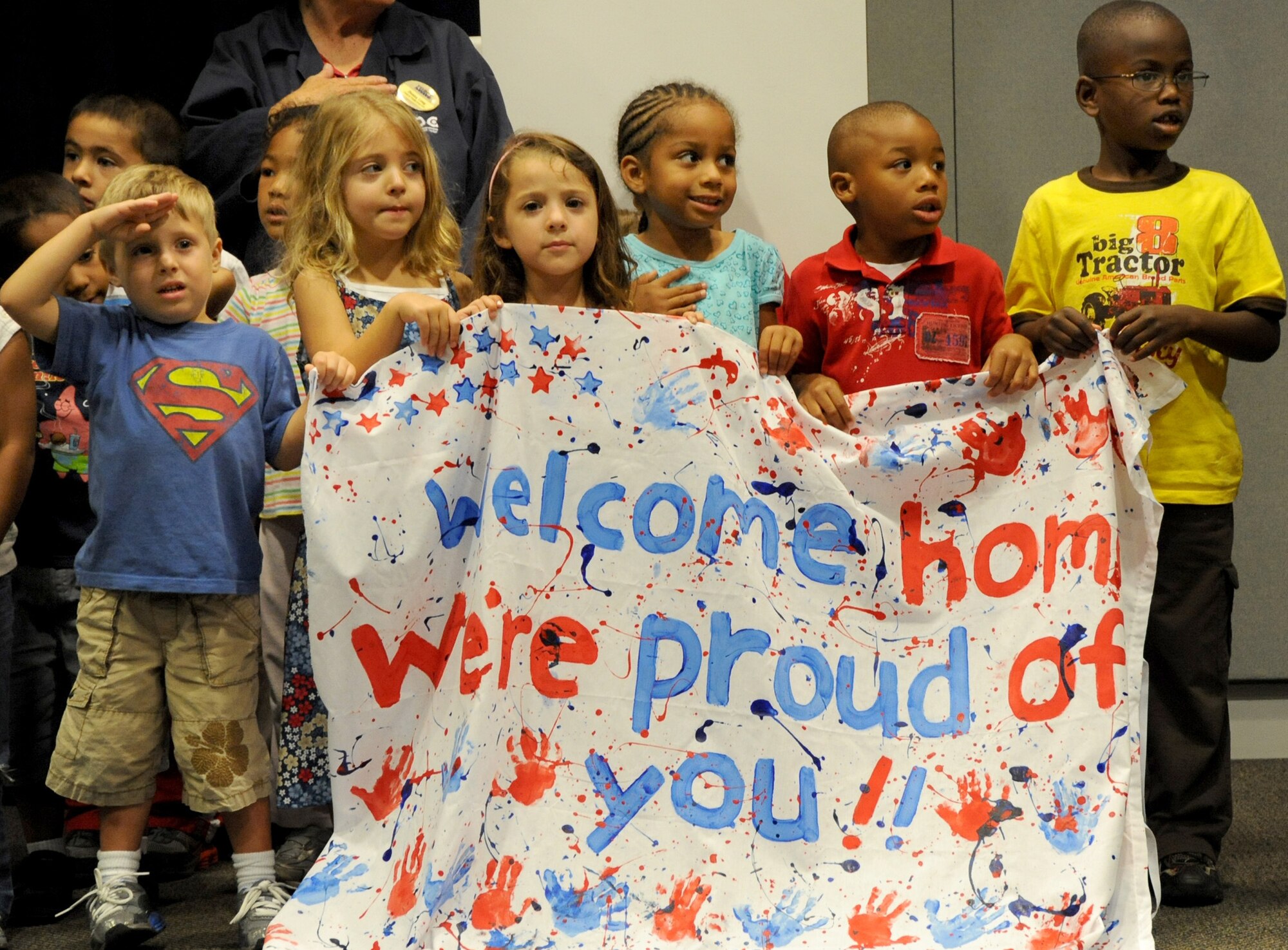 Children from the Los Angeles AFB Child Development Center salute returning Airmen at the recent Welcome Home Ceremony, June 23. The children sang the National Anthem during the ceremony. (Photo by Lou Hernandez)