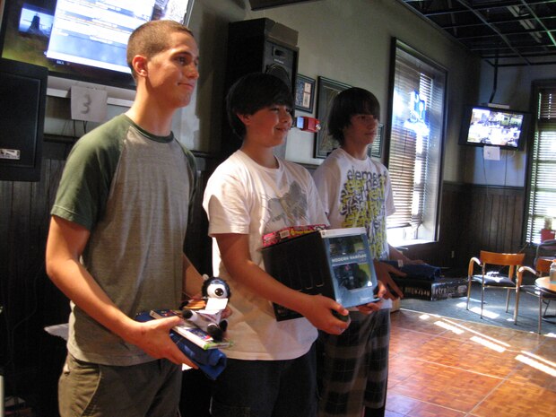 Adam Pollard, left, Derek Cormier and Ian Dahan, right, accept their prizes for being the winners of the Modern Warfare tournament which was held at the Charleston Club on Joint Base Charleston, S.C., June 26, 2010. The competition required participants to pay an enrollment fee and all proceeds benefited Airmen Against Drunk Driving. (U.S. Air Force photo/Airman 1st Class Haleigh Greer)