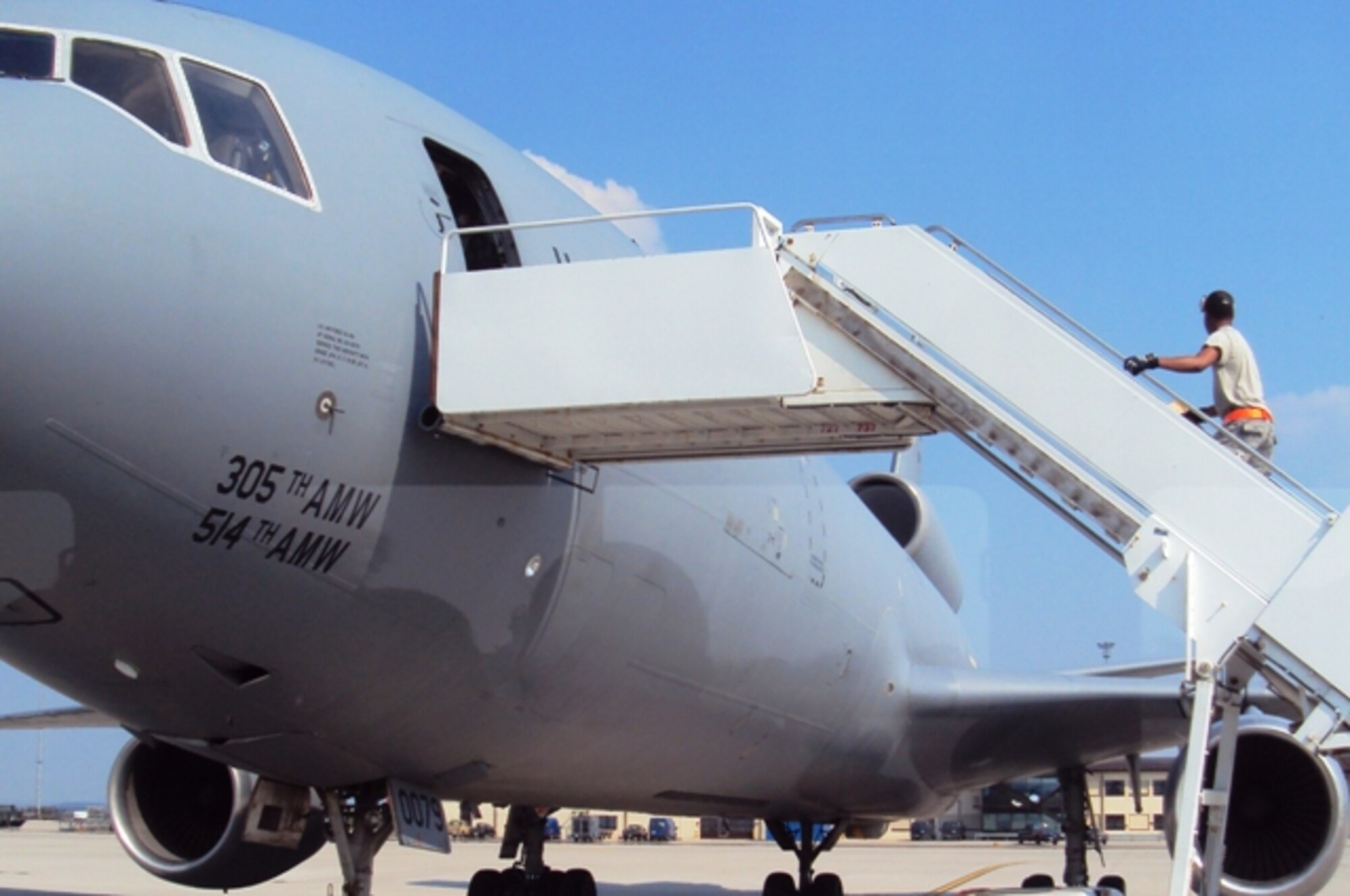 An air transportation Airman assigned to the Air Mobility Command terminal at Spangdahlem Air Base, Germany, climbs the stairs in to a KC-10 Extender from the 305th Air Mobility Wing, Joint Base McGuire-Dix-Lakehurst, N.J., during operations June 24, 2010, at Spangdahlem. (U.S. Air Force Photo/Master Sgt. Scott T. Sturkol)