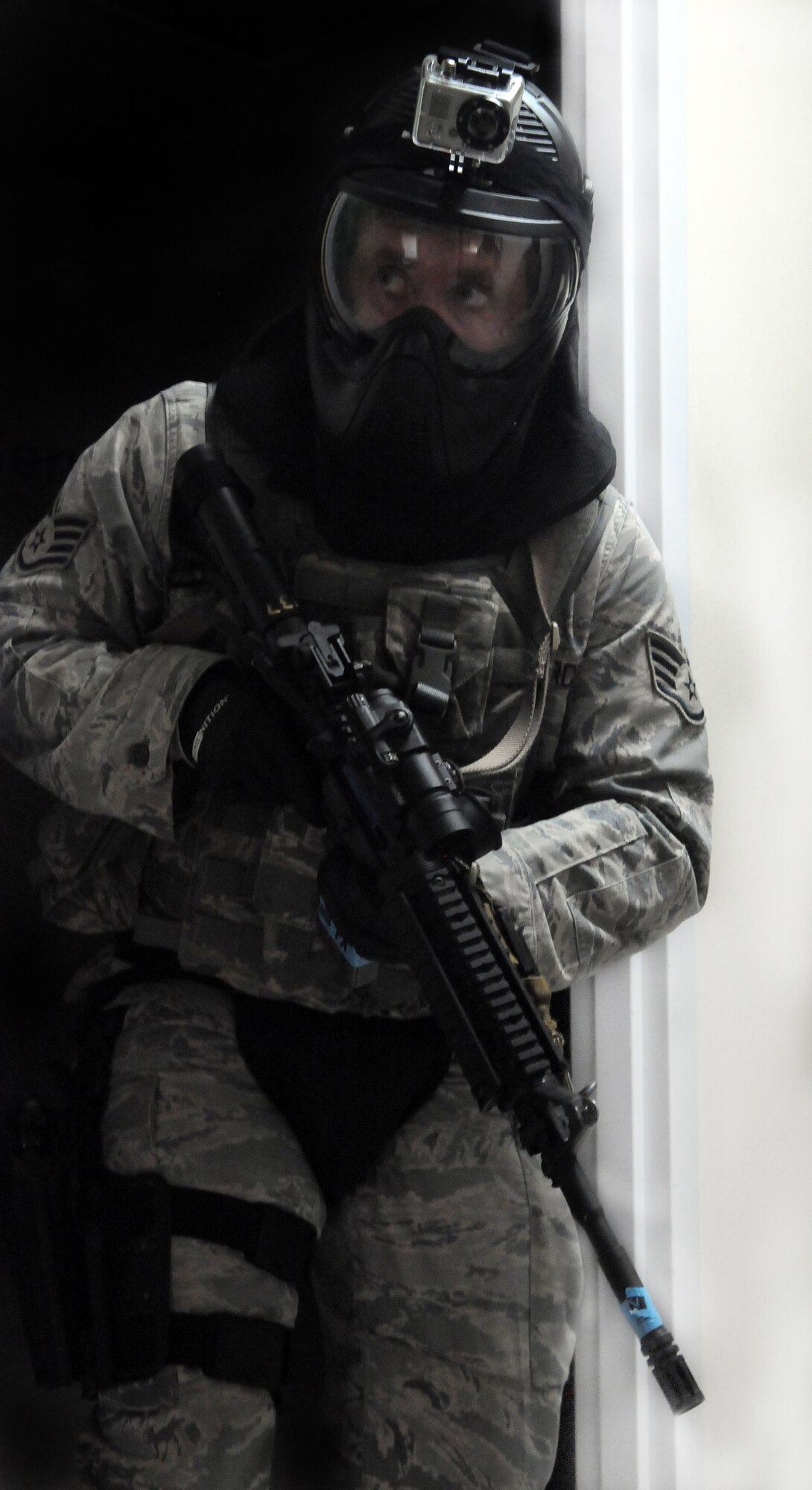 A 354th Security Forces member guards an entryway while his team finishes clearing a room June 25, 2010, Eielson Air Force Base, Alaska.  SF members were handpicked to undergo High Risk Response Training, a new and improved active shooter trainer course that instructs base security personnel to neutralize a high-risk threat.  (U.S. Air Force photo/Airman 1st Class Yash Rojas) 