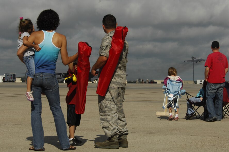 MINOT AIR FORCE BASE, N.D. – Staff Sgt. James Marquez, 5th Aircraft Maintenance Squadron crew chief, watches a B-52H Stratofortresses take off along with wife, Natalie, son, Layne, and daughter, Talyn, during a rapid launch exercise here June 28. As a finale to the week-long exercise, family members were invited to watch several B-52s from Minot and Barksdale AFB, La., take off in rapid succession, signaling the end of the training mission. (U.S. Air Force photo by Tech. Sgt. Thomas Dow)