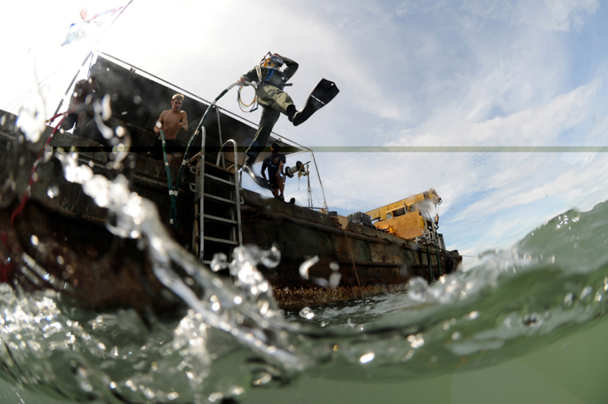 Petty Officer 2nd Class Jessie Trujillo, diver, a member of Mobile Diving Salvage Unit 1, jumps off a barge for a surface supply dive in support of a Joint POW/MIA Accounting Command recovery mission in the Nghe An province, Socialist Republic of Vietnam. The mission of JPAC is to achieve the fullest possible accounting of all Americans missing as a result of the nation's past conflicts. (JPAC photo by Mass Communication Specialist 1st Class Anderson Bomjardim/Released)