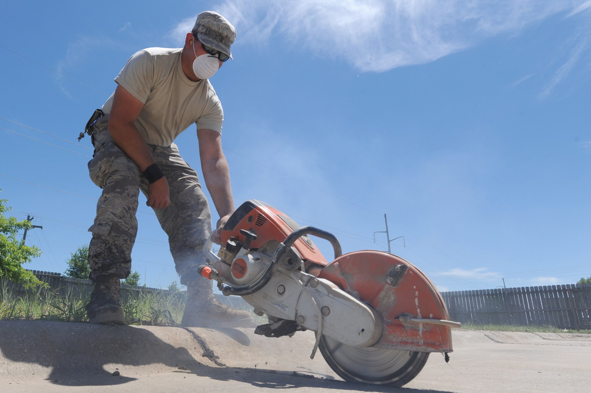 WHITEMAN AIR FORCE BASE, Mo. - Senior Airman Travis Knighten, 509th Civil Engineer Squadron payment and equipment operator, grinds out tar sealant from the crevices of a parking lot, Tuesday. Repairing the sealant protects the concrete from weather and helps prevent cracking.(U.S. Air Force photo/ Senior Airman Carlin Leslie)
 