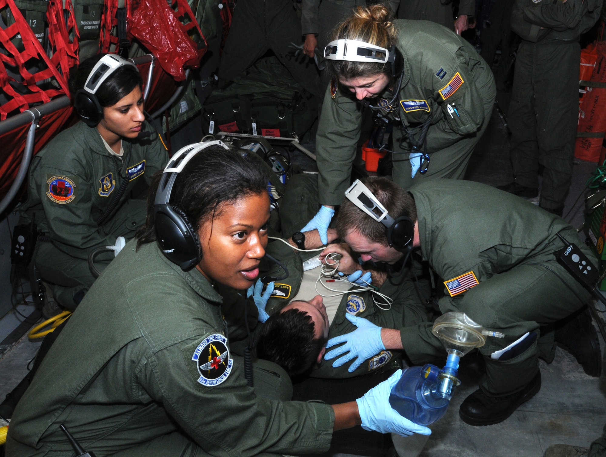 Airmen from the 36th Aeromedical Evacuation Squadron and the 43rd AES treat simulated patient, Staff Sgt. Nikolaus Falcon, 43rd AES, for combat injuries during an in-flight exercise June 26. The Total Force Integration of aeromedical evacuation specialists from the Reserve and regular Air Force was the theme behind a three-day training mission that took place on a KC-135R Stratotanker. The 459th AES also participated in the blended training by providing hands-on instruction on Patient Support Pallet operations. (U.S. Air Force photo/Staff Sgt. Steve Lewis)   