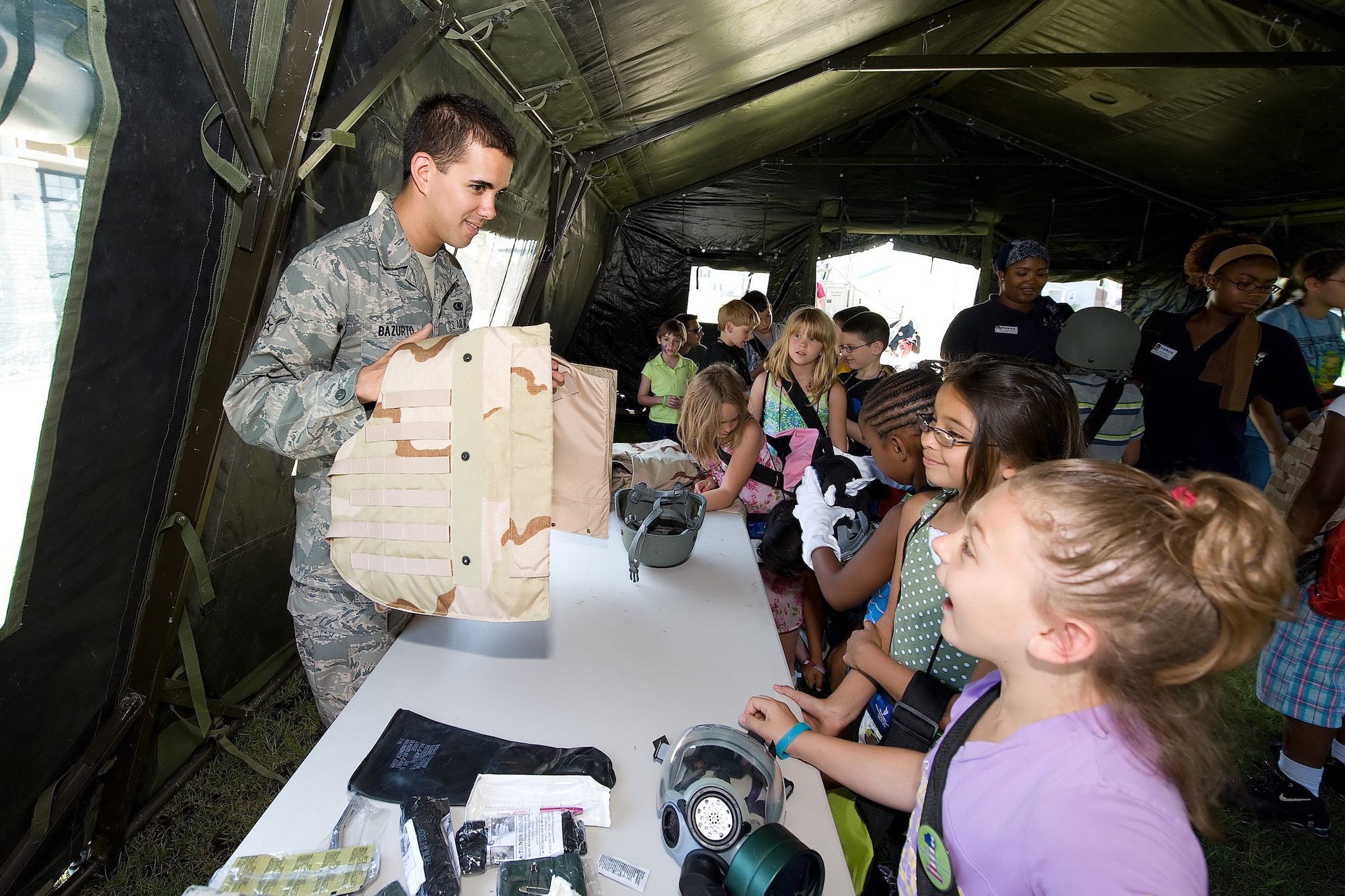 Airman Matt Bazurto, 436th Logistics Readiness Squadron, displays a flak jacket during the Children's Mobility Line June 25, 2010. The mobility line's goal is to instill the message that children are just as important as their parents to the mission. (U.S. Air Force photo by Jason Minto/Released)
