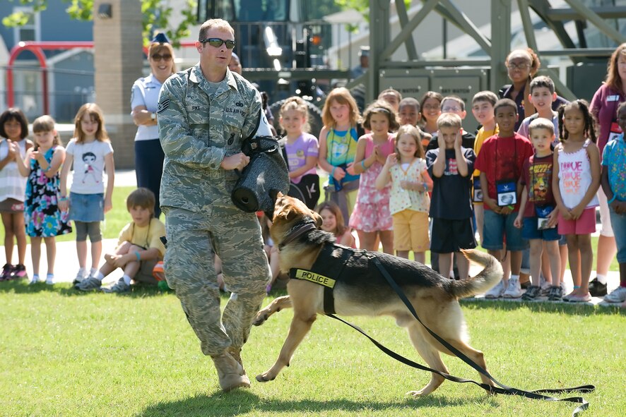 Staff Sgt. Adam Fike, 436th Security Forces Squadron, assists during a K-9 demonstration during the Children's Mobility Line June 25, 2010. The mobility line featured many demonstrations and booths to inform children about the proccesses of deployment. (U.S. Air Force photo by Jason Minto/Released)