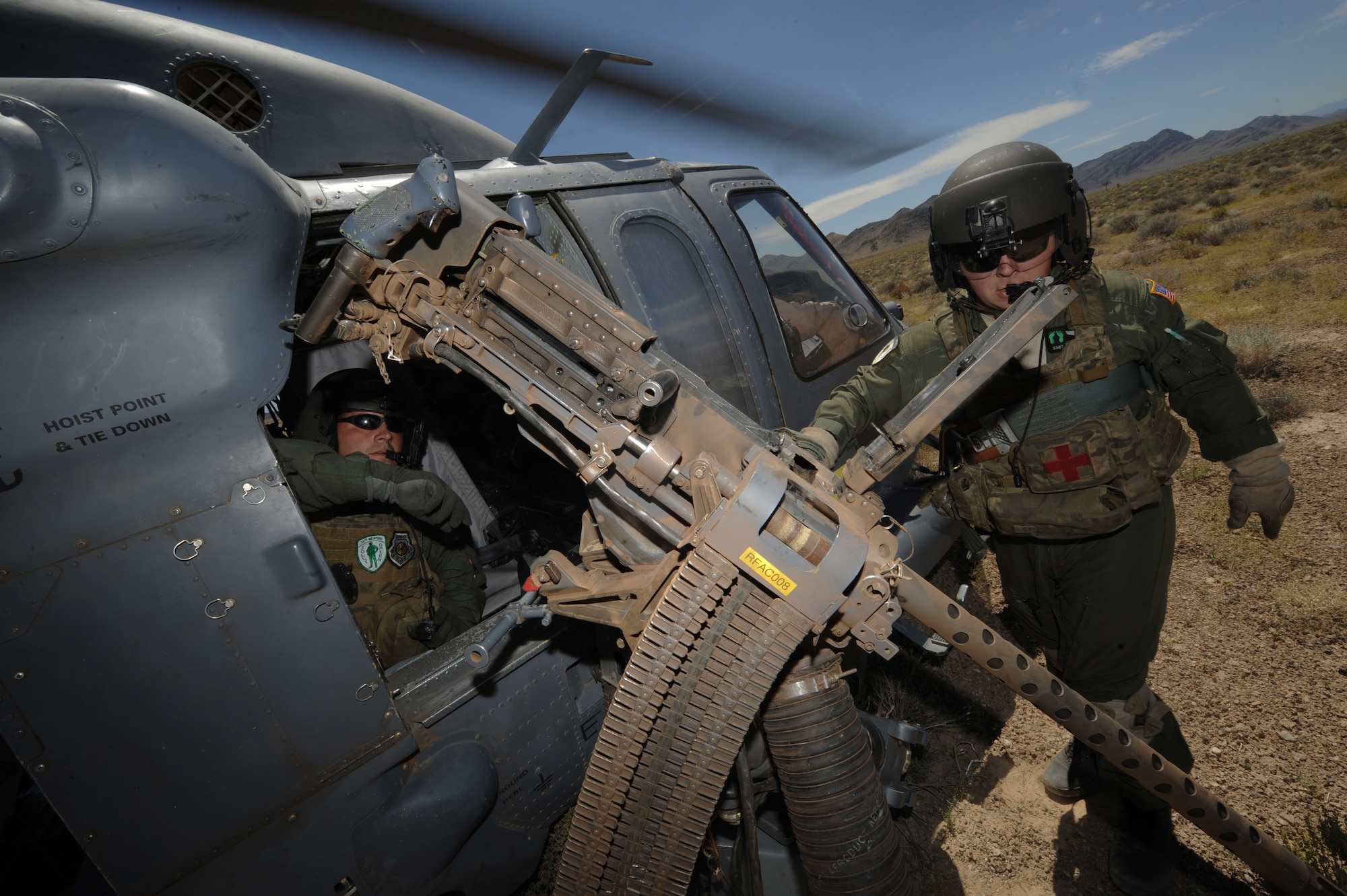 (Left) Tech. Sgt. Michael Vincent and Staff Sgt. Andrew Gibson prepare to reload an HH-60 Pave Hawk helicopter .50- caliber machine gun during a fixed, forward firing mission over the Nevada Test and Training Ranges on 25 June, 2010. Sgt Vincent is a flight engineer from the U.S. Air Force Weapons School, 34TH Weapons Squadron, Nellis Air Force Base, Nev., and Sgt. Gibson is also a flight engineer assigned to the 129th Rescue Squadron, Moffett Field, Calif.  
(U.S. Air Force photo by Master Sgt. Kevin Gruenwald/Released)

