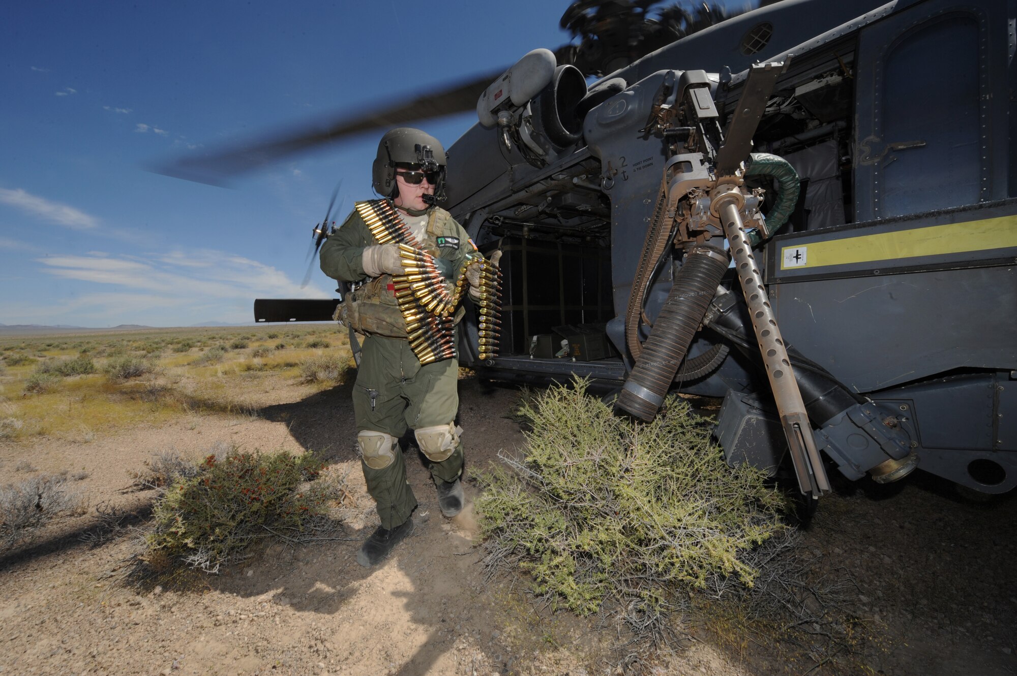 Staff Sgt. Andrew Gibson, carries .50- caliber machine gun ammo to reload an HH-60 Pave Hawk helicopter during a fixed, forward firing mission over the Nevada Test and Training Ranges on 25 June, 2010.  Sgt. Gibson is a flight engineer assigned to the 129th Rescue Squadron, Moffett Field, Calif.  
(U.S. Air Force photo by Master Sgt. Kevin Gruenwald/Released)
