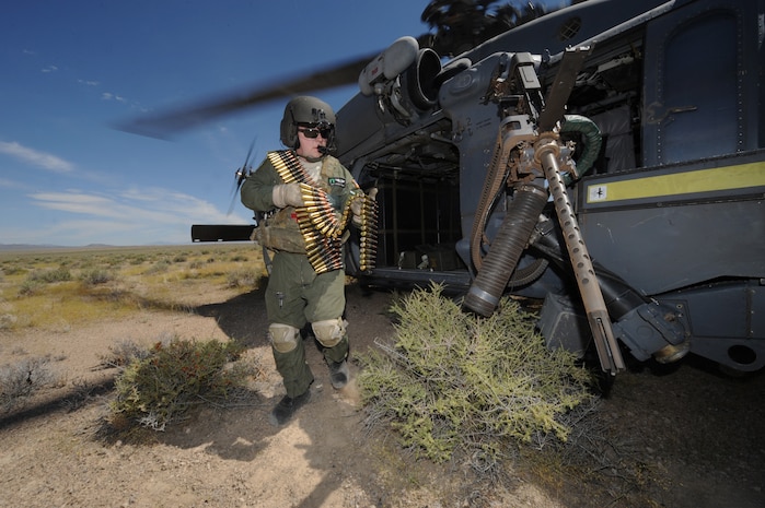 Staff Sgt. Andrew Gibson, carries .50- caliber machine gun ammo to reload an HH-60 Pave Hawk helicopter during a fixed, forward firing mission over the Nevada Test and Training Ranges on 25 June, 2010.  Sgt. Gibson is a flight engineer assigned to the 129th Rescue Squadron, Moffett Field, Calif.  (U.S. Air Force photo by Master Sgt. Kevin Gruenwald/Released)
