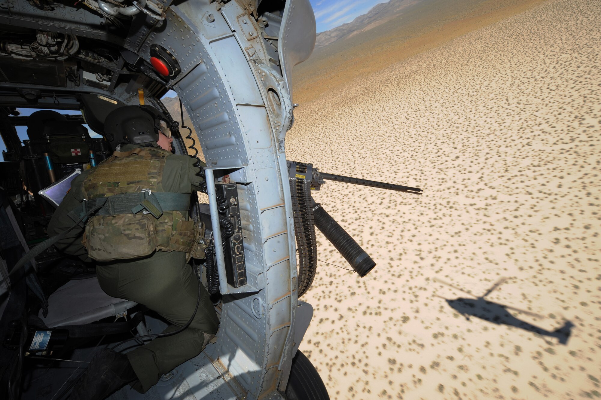 Staff Sgt. Andrew Gibson, scans terrain for training targets from an HH-60 Pave Hawk helicopter during a fixed, forward firing mission over the Nevada Test and Training Ranges on 25 June, 2010. Sgt. Gibson is a flight engineer assigned to the 129th Rescue Squadron, Moffett Field, Calif.  
(U.S. Air Force photo by Master Sgt. Kevin Gruenwald/Released)

