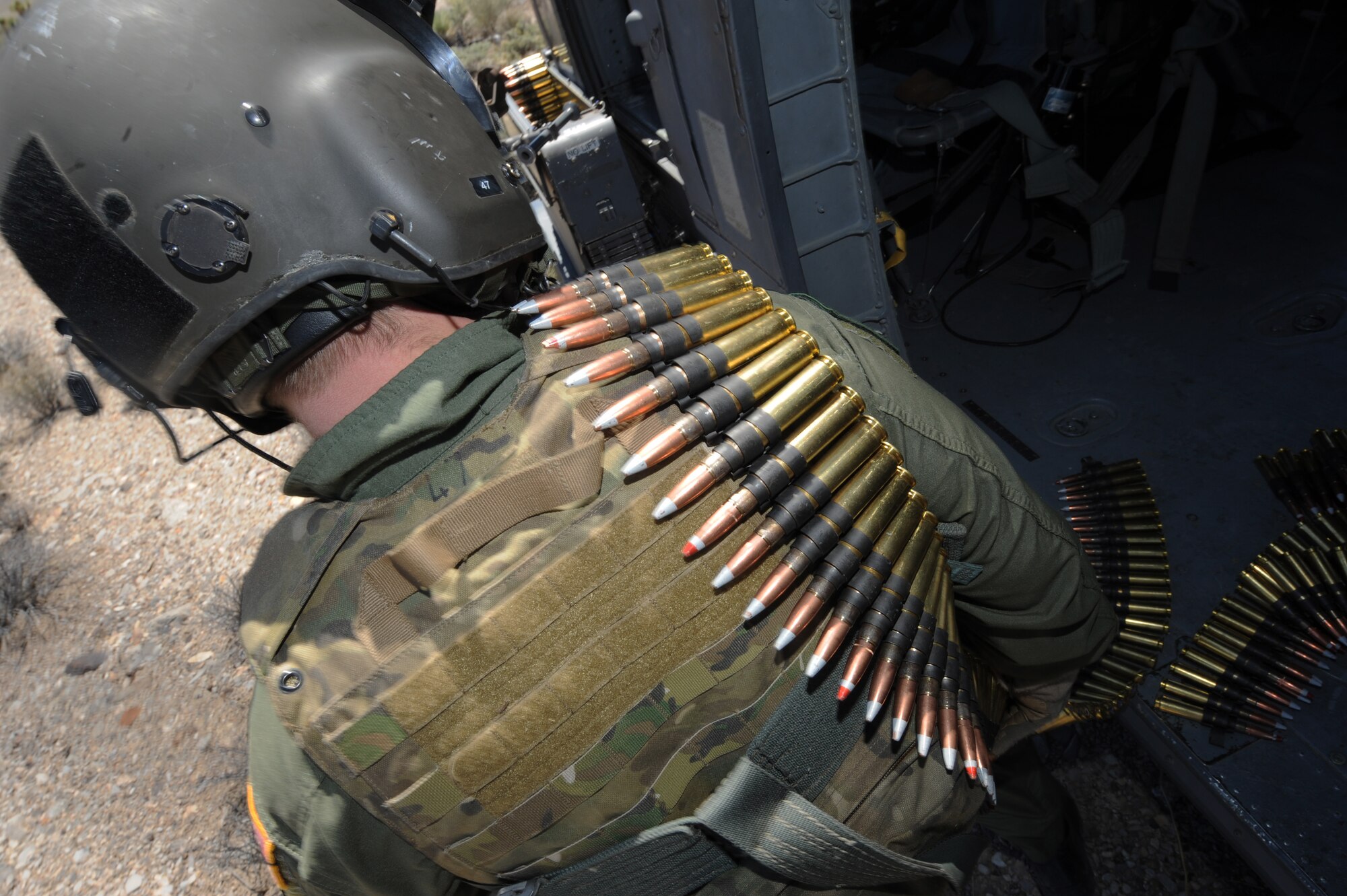 Staff Sgt. Andrew Gibson, carries .50- caliber machine gun ammo to reload from an HH-60 Pave Hawk helicopter during a fixed, forward firing mission over the Nevada Test and Training Ranges on 25 June, 2010.  Sgt. Gibson is a flight engineer assigned to the 129th Rescue Squadron, Moffett Field, Calif.  

(U.S. Air Force photo by Master Sgt. Kevin Gruenwald/Released)

