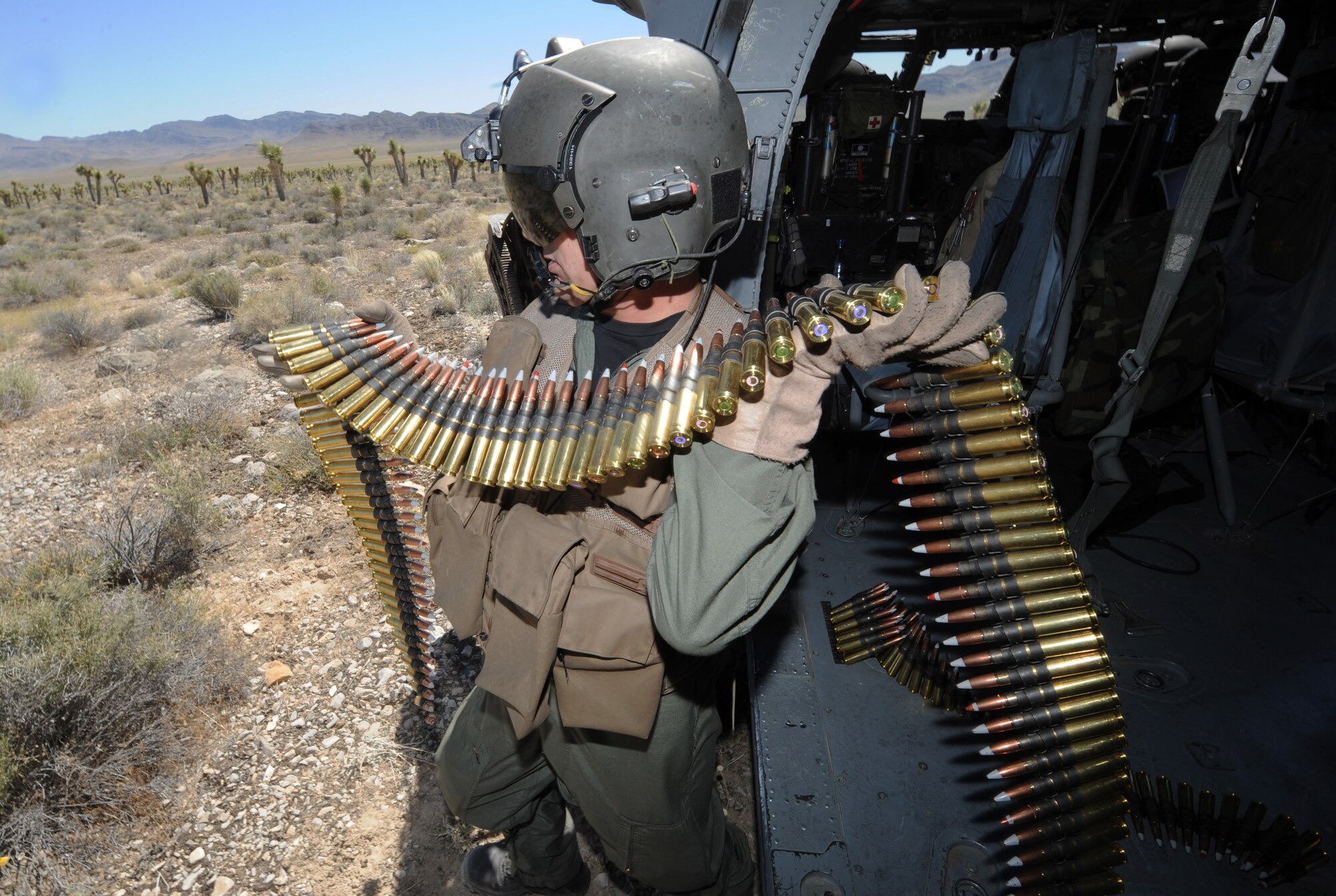 Staff Sgt. Andrew Gibson, carries .50- caliber machine gun ammo to reload from an HH-60 Pave Hawk helicopter during a fixed, forward firing mission over the Nevada Test and Training Ranges on 25 June, 2010.  Sgt. Gibson is a flight engineer assigned to the 129th Rescue Squadron, Moffett Field, Calif.  
(U.S. Air Force photo by Master Sgt. Kevin Gruenwald/Released)
