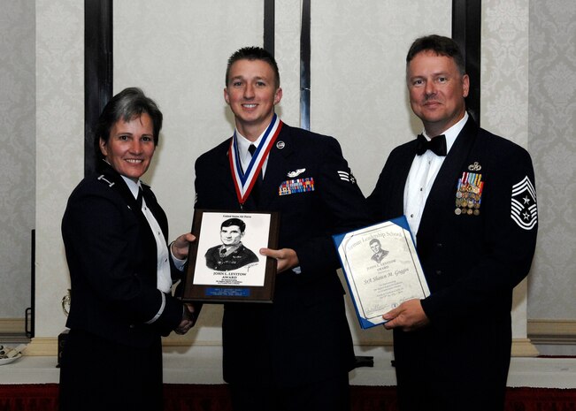 Col. Martha Meeker, left, and Chief Master Sgt. Mike Ivey, right, present Senior Airman Shawn Goggin with the John L. Levitow Award during the Airman Leadership School Class 10-E graduation at the Charleston Club here June 24. The award is given for a student's exemplary demonstration of excellence both as a leader and a scholar. Colonel Meeker is the 628th Air Base Wing commander, Chief Ivey is the 628 ABW command chief, and Airman Goggin is a loadmaster with the 14th Airlift Squadron. (U.S. Air Force photo/Senior Airman Timothy Taylor)