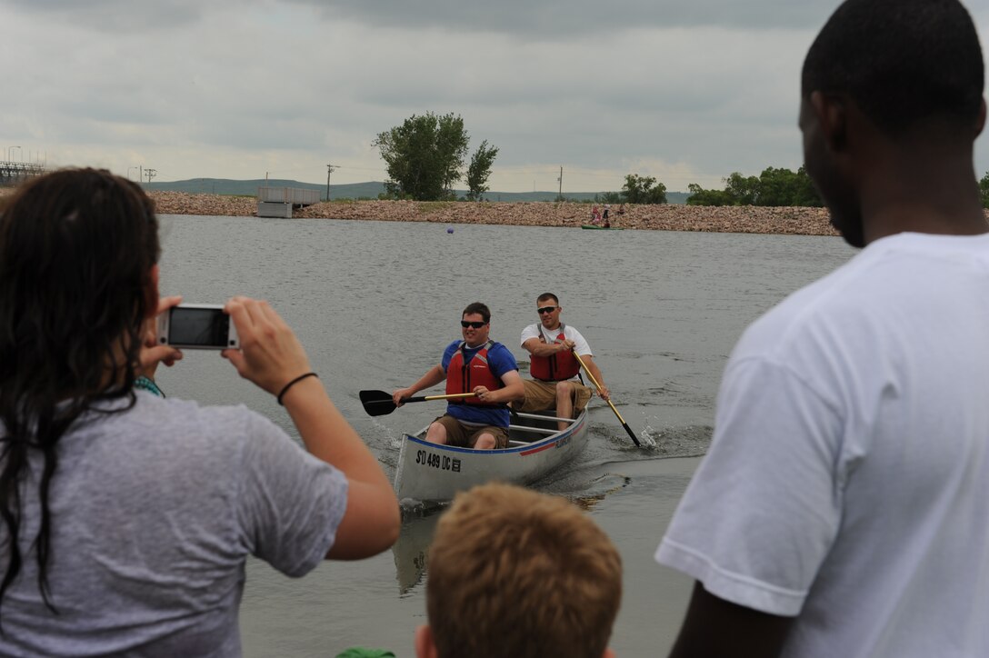 ELLSWORTH AIR FORCE BASE, S.D.-- Participants in the canoe race pull into the finish line during the Party at the Lake, June 26. This annual event hosted by the Airman and Family Readiness Center and Outdoor Recreation was part of the bases' Year of the Air Force Family initiative held throughout the year. (U.S. Air Force photo/Master Sgt. Loren J. Bonser)

