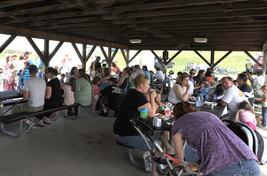 ELLSWORTH AIR FORCE BASE, S.D.-- Ellsworth Airmen and their families eat lunch during the Party at the Lake  here June 26. This annual event, hosted by the Airman and Family Readiness Center and Outdoor Recreation, had activities for everyone-including jumping castles, a  DJ, and free door  prizes. (U.S. Air Force photo/Master Sgt. Loren J. Bonser)

