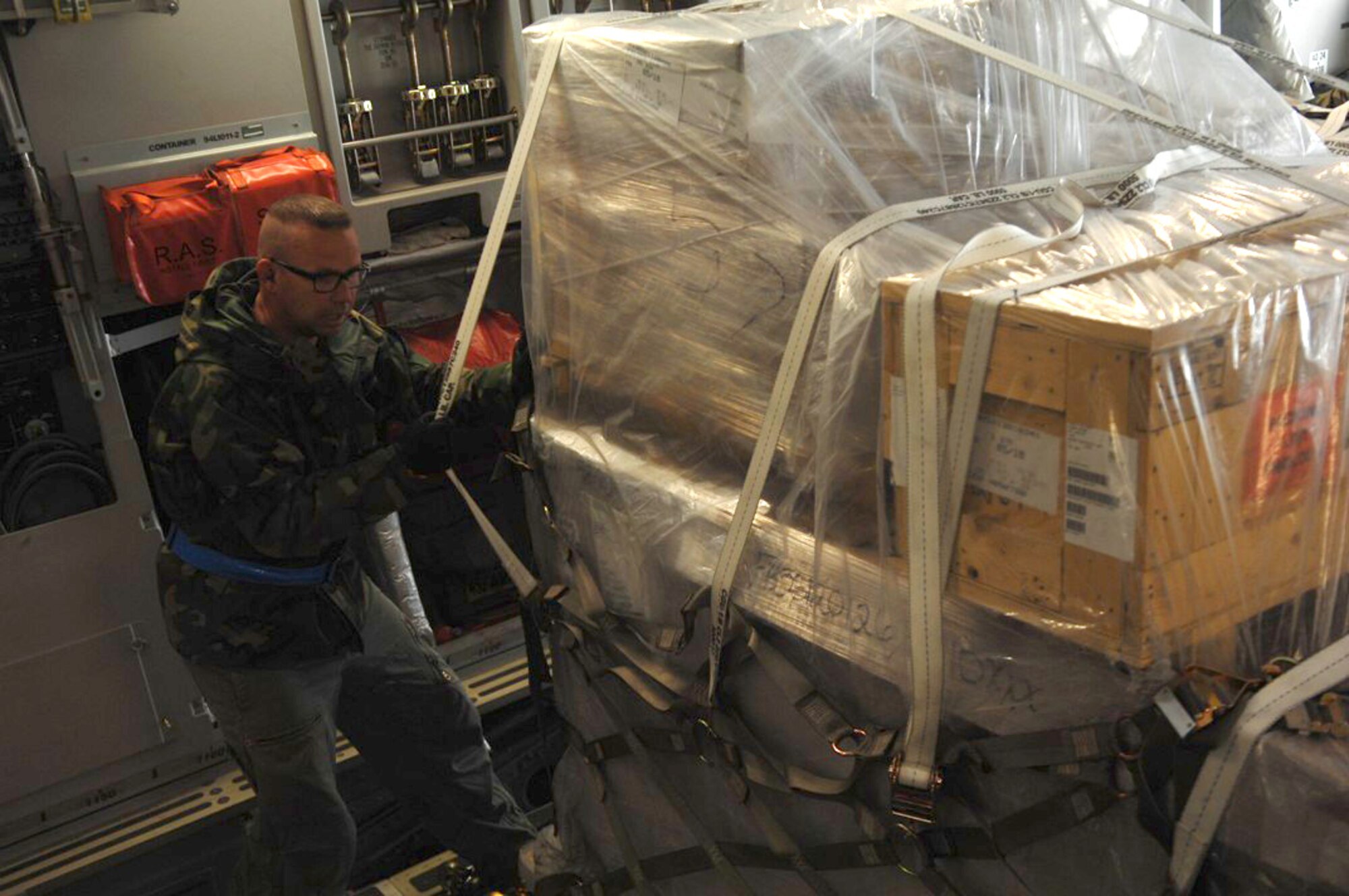 Kasper Chevalier ensures cargo is properly secured June 23, 2010 at Ramstein Air Base, Germany. Mr. Chevalier is an aerial porter in the 721st Aerial Port Squadron. (U.S. Air Force photo/Tech. Sgt. Michael Voss)