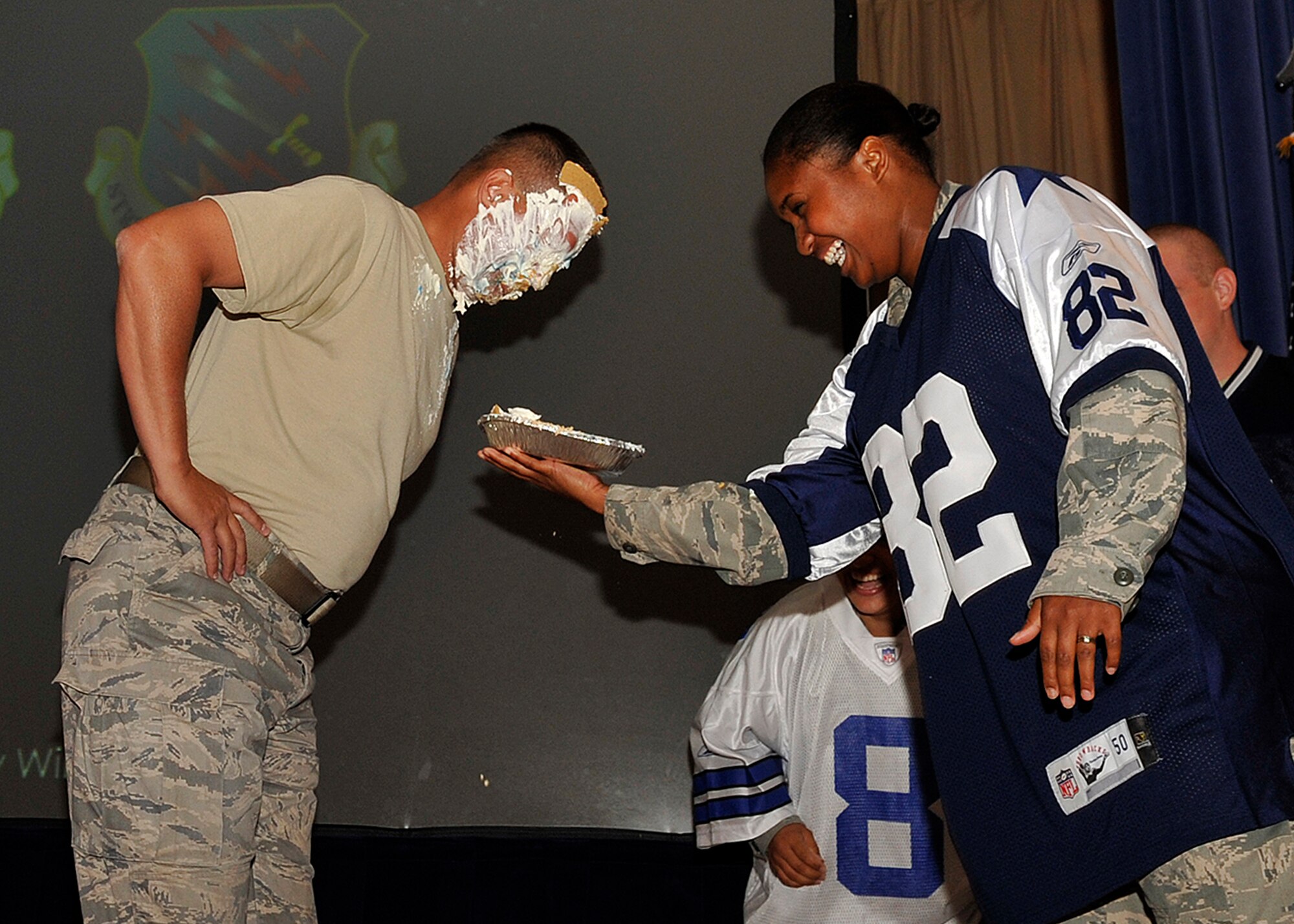 Staff Sgt. Melanie Curtis, 21st Medical Group, won the chance to put a pie in the face of her boss, Col. John Sell, 21st Medical Group commander, by raising money for the Air Force Assistance Fund. Sergeant Curtis deliberately wore a Dallas Cowboys football jersey to tease the commander because it is his least favorite team, she said. The pie-in-the-face event happened June 25 at the Peterson Air Force Base auditorium following Col. Stephen N. Whiting’s commander’s call. During the afternoon briefing Al Strait, 21st Space Wing director of staff, got a pie smashed in his face. (U.S. Air Force photo/Rob Bussard)