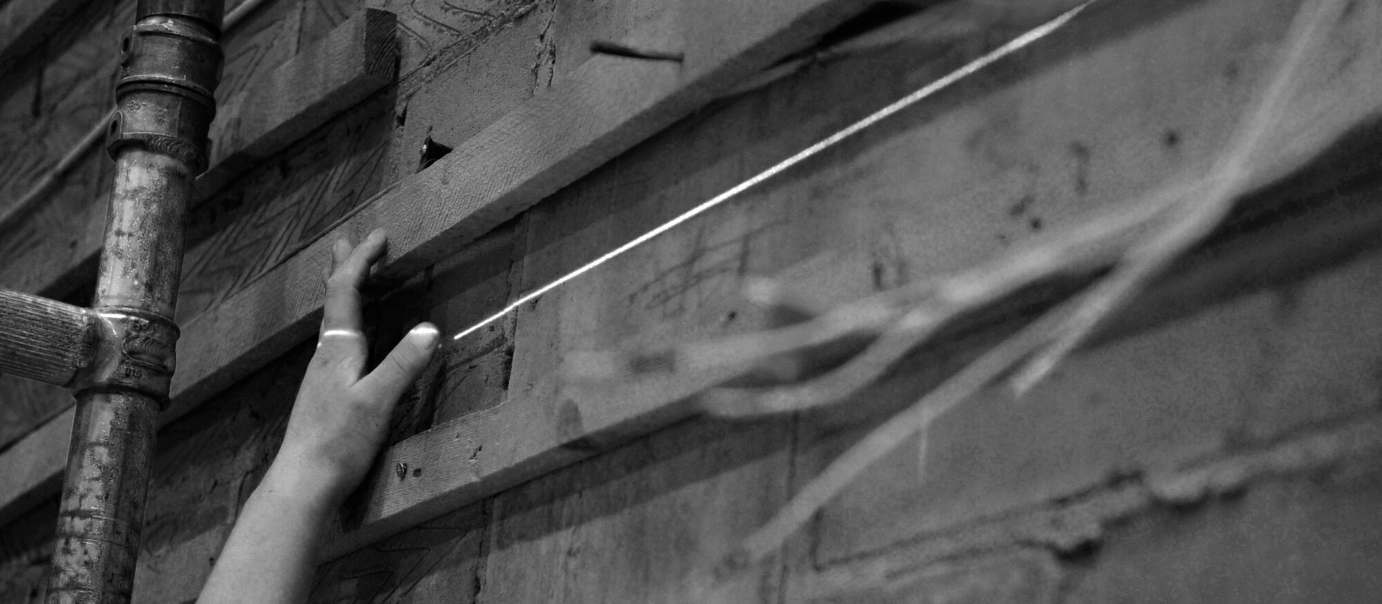 RAF MILDENHALL, England – Local contractors use a laser level to ensure the mounting rails for the sound proof walls are straight at the Base Theater June 29.  The renovation of the theater is scheduled to continue through July.  (U.S. Air Force photo/Staff Sgt. Christopher L. Ingersoll)