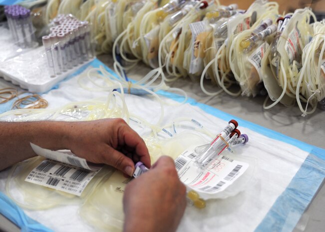An American Red Cross technician applies a label to one of many vials that will be used during blood donation at the Red Cross mobile blood drive at the Sports and Fitness Center June 23, 2010, at Joint Base Charleston, S.C. The vials are drawn from a smaller bag that collects blood before the donation begins using tubing and a needle. The American Red Cross collected 26 pints from ALYX Component Collection System donors, 77 pints from standard donors and 103 pints total. Through ALYX, donors are able to give two units of red cells during one visit, providing double the impact for patients requiring the most critically needed blood types. (U.S. Air Force Photo/Senior Airman Timothy Taylor)