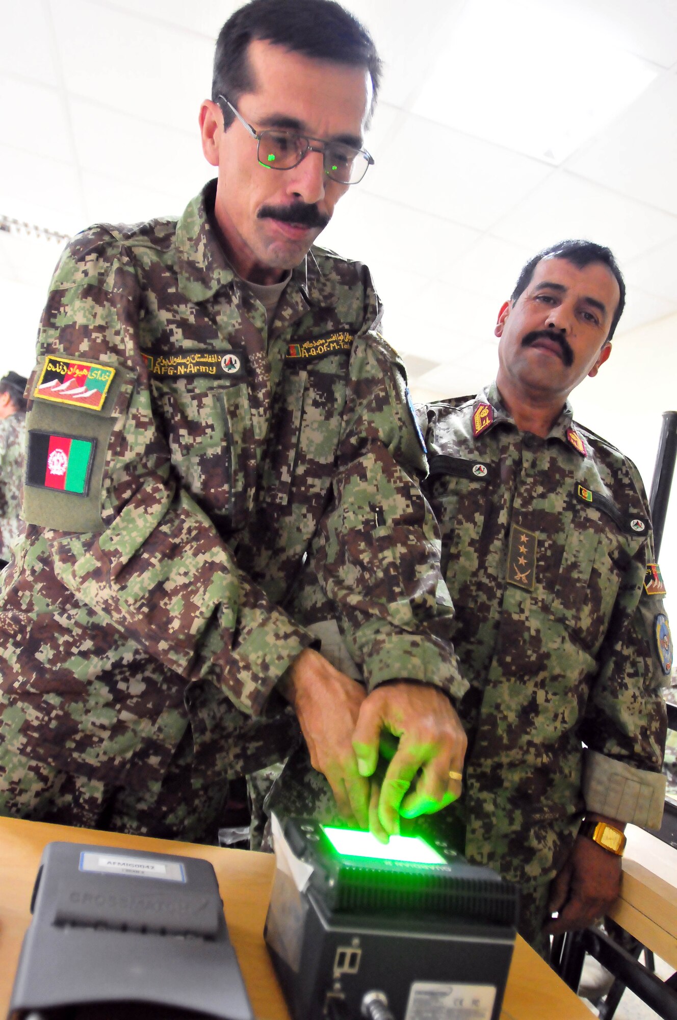 1006-N-6031Q-001 KABUL, Afghanistan -- Soldiers from the Afghan National Air Force participate in biometric data collection of their personal history, iris scan, thumb print, and urinalysis under a new accountability program in the Afghan Air Force. (US Navy photo by Mass Communication Specialist 2nd Class David Quillen/ RELEASED). 