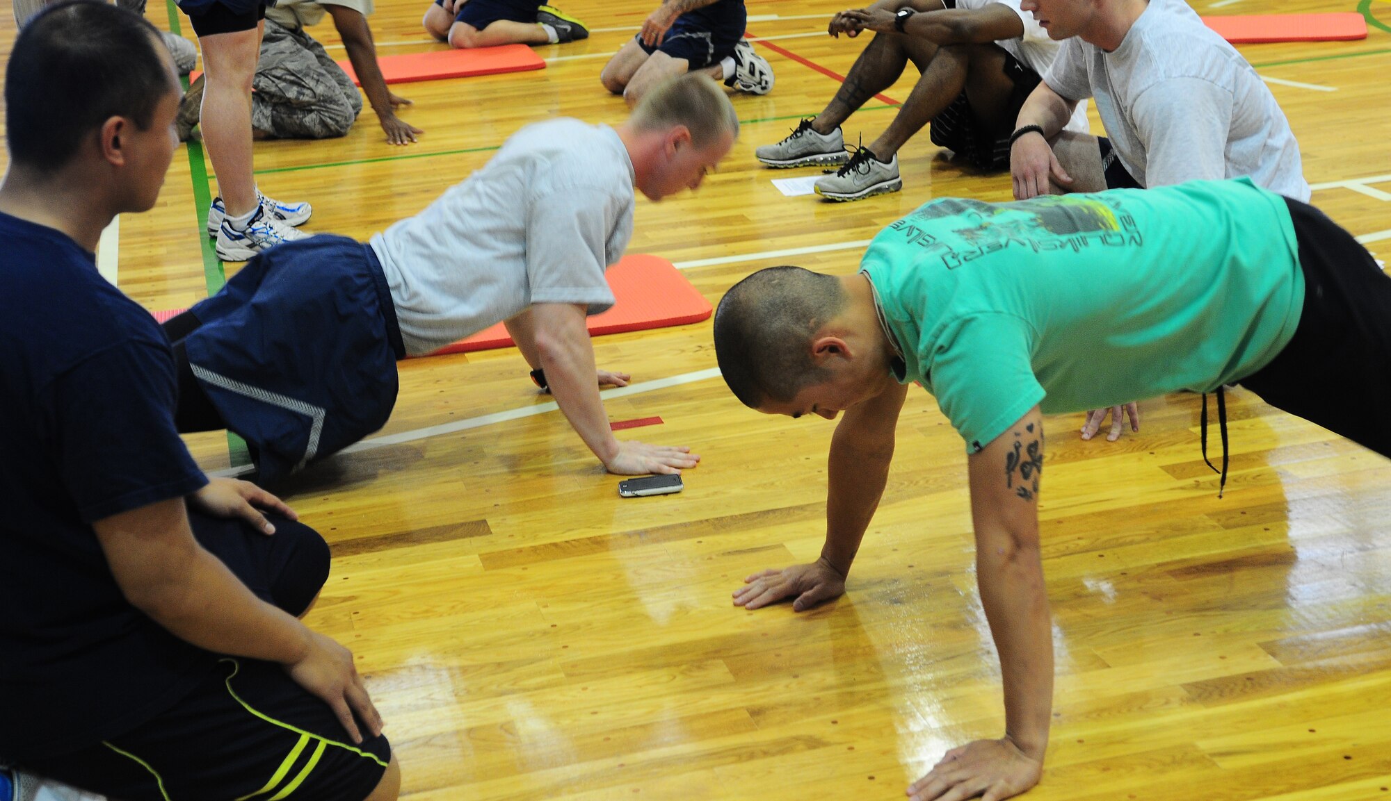 YOKOTA AIR BASE, Japan -- Airmen from Team Yokota participate in a push-up/ sit-up fundraiser hosted by the Chief's Group at the Samurai Fitness Center here, June 25. Funds raised from the event were donated to the Enlisted Village and the Chief's Group to improve the quality of living for Airmen. (U.S. Air Force photo/Airman 1st Class Lynsie Lorenz)