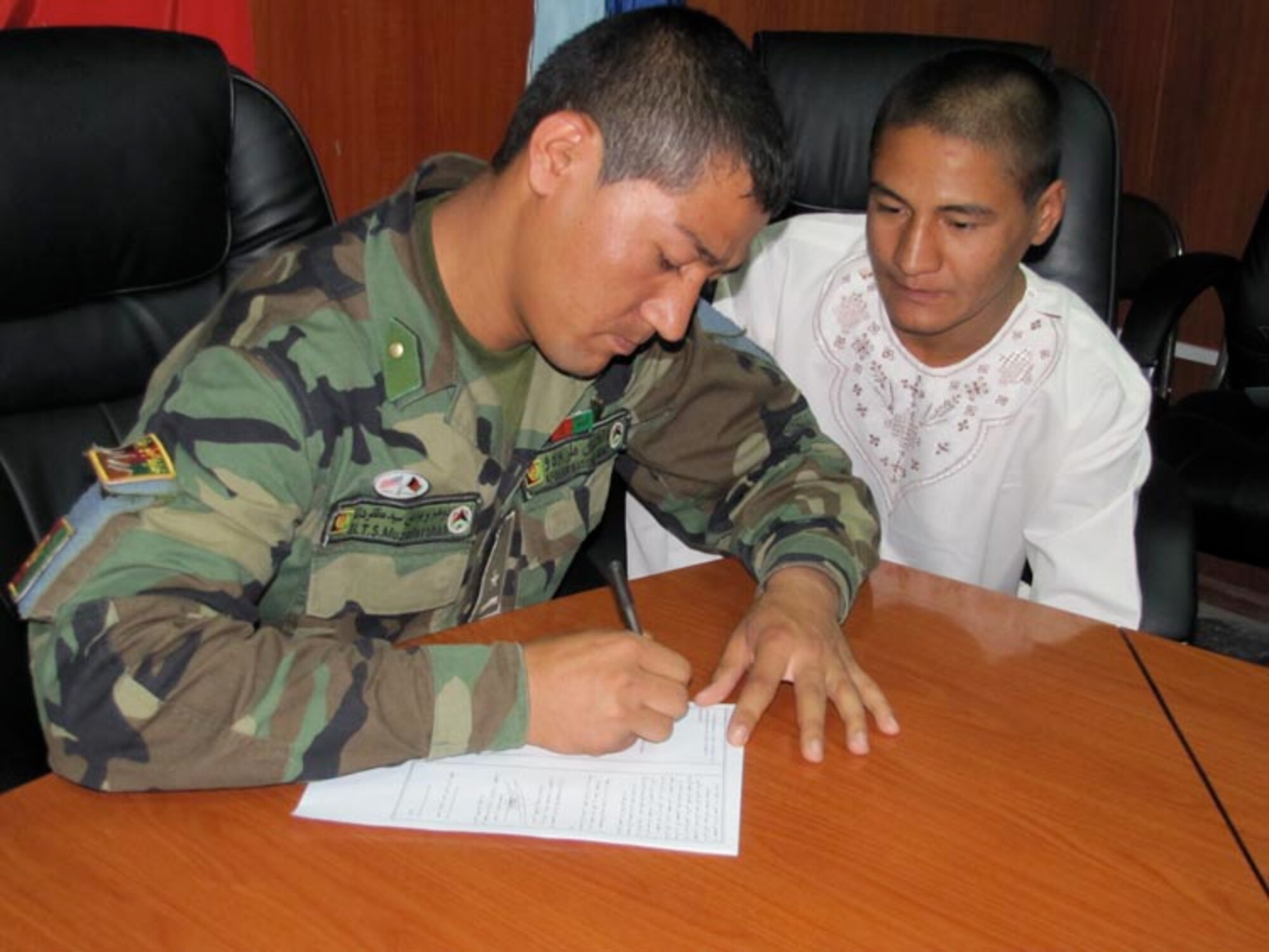 Afghan National Army Air Force 2nd Lieutenant Said Muzafarshah Anwari signs his service commitment to attend Undergraduate Pilot Training in the United States on Jun. 20, 2010 at the Afghan National Army Air Force base in Kabul, Afghanistan (U.S. Navy photo by Mass Communications Specialist First Class Elizabeth Burke/RELEASED).