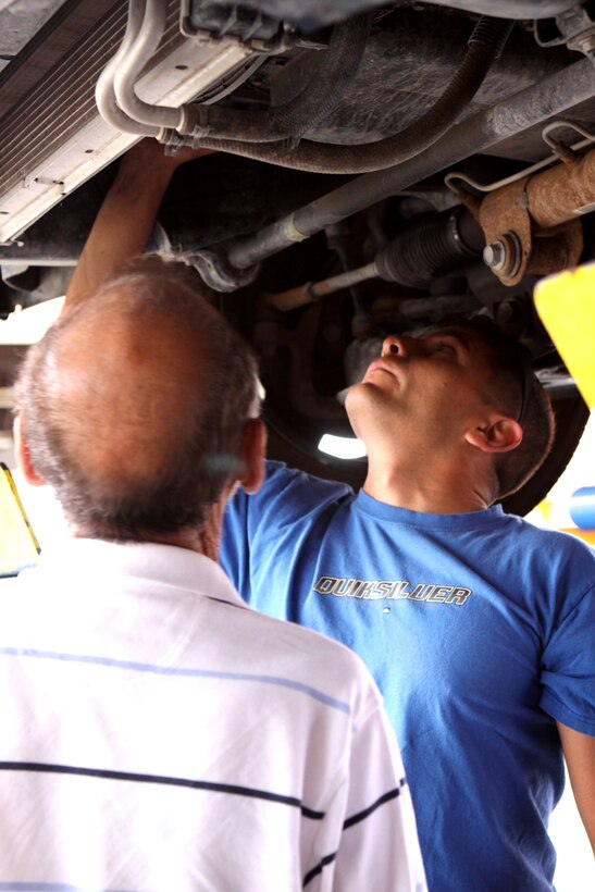 Staff Sgt. Juan Fuentes (right), legal services, Combat Logistic Regiment 17, 1st Marine Logistics Group, Camp Pendleton, makes repairs to his car at the base’s 13 Area Auto Skills Center. The facility not only has all the necessary tools to do personal auto work, but they are also armed with a knowledgeable staff of mechanics who are Automotive Service Excellence certified.