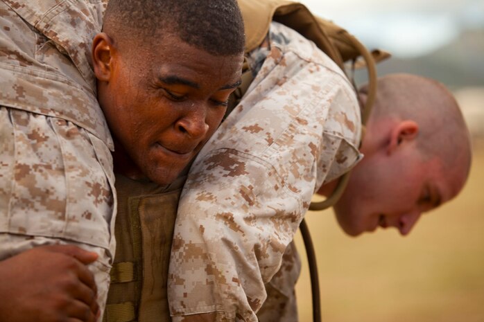 Cpl. Derek Rosse, training noncommissioned officer, training and operations section, 3rd Radio Battalion, and a student with Marine Corps Martial Arts Instructor Course 06-10, buddy squats fellow MAIC student Cpl. Tyler Stevens, signals intelligence operator, Company I, Marine Cryptologic Support Battalion, Kunia, during a landing zone drill at LZ 216 on Marine Corps Base Hawaii, June 29, 2010. The grueling three-week course, built around the Marine Corps Martial Arts Program, is an excellent way for officers and noncommissioned officers to prepare for their annual Combat Fitness Tests.