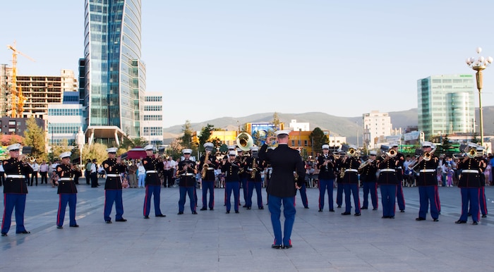 Chief Warrant Officer 2 Bryan Sherlock, U.S. Marine Corps Forces, Pacific Concert Band officer-in-charge, leads the MarForPac band as they show off their musical talent before a crowd of more than 300 people in Sukhbaatar Square, Ulaanbaatar, Mongolia, June 30. The MarForPac Band joined the Central Orchestra of the General Staff of the Mongolian Armed Forces (MAF Band) to host the free, public concert.