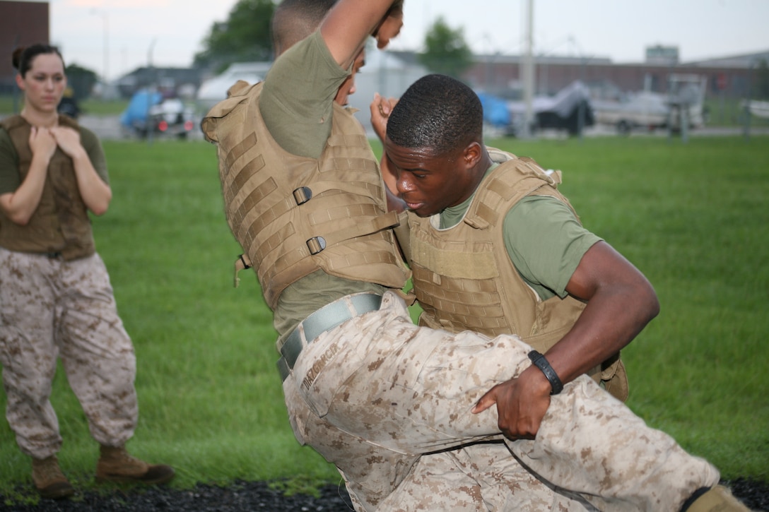 Pfc. Taylor M. Diaz Garcia gets taken down by Lance Cpl. Luchmy Luc during MCMAP training Wednesday, June 30 on the O-course PT field. They tested for their new Green Belts on Friday, July 2. The Green Belt is the third level of belt of a total of five possible belts.