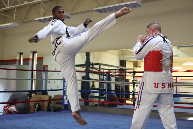Cpl. Michael King, an administrative assistant to the chaplain of the Marine Corps, performs a jumping turning kick on Cpl. Waylon Parker at the Joint Base Myer-Henderson Hall gym in Arlington, Va., June 30. King has been practicing this martial art since he was 19 years old.