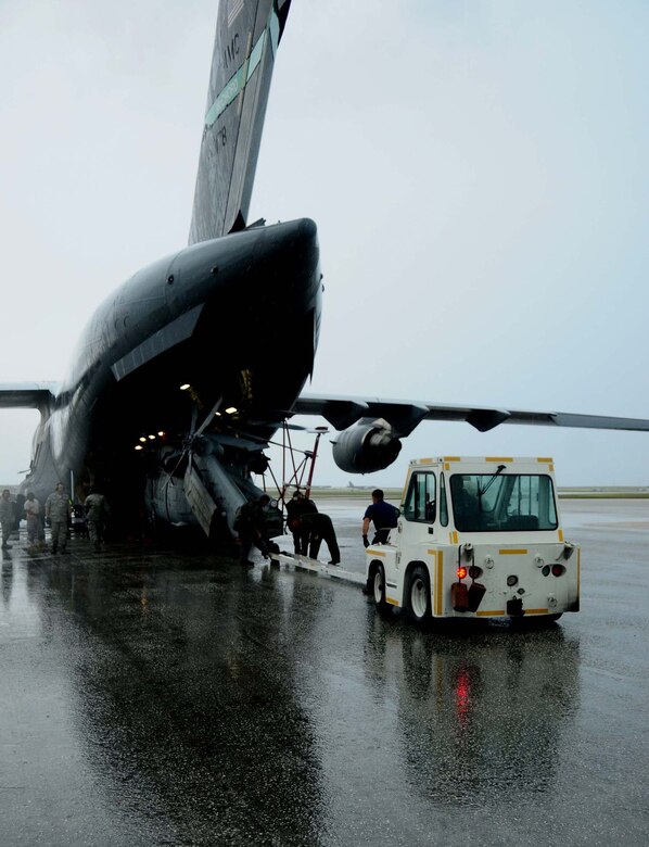 ANDERSEN AIR FORCE BASE, Guam ? Air Force personnel work with Airmen from the Helicopter Sea Combat Squadron 25 to unload two MH-60S Knighthawk from a C-17 Globemaster here June 23, 2010. The aircraft arrived as part of the HSC -25 air asset rotation. The massive undertaking of unloading the two aircraft showcased the team work that is central to Joint Region Marianas.