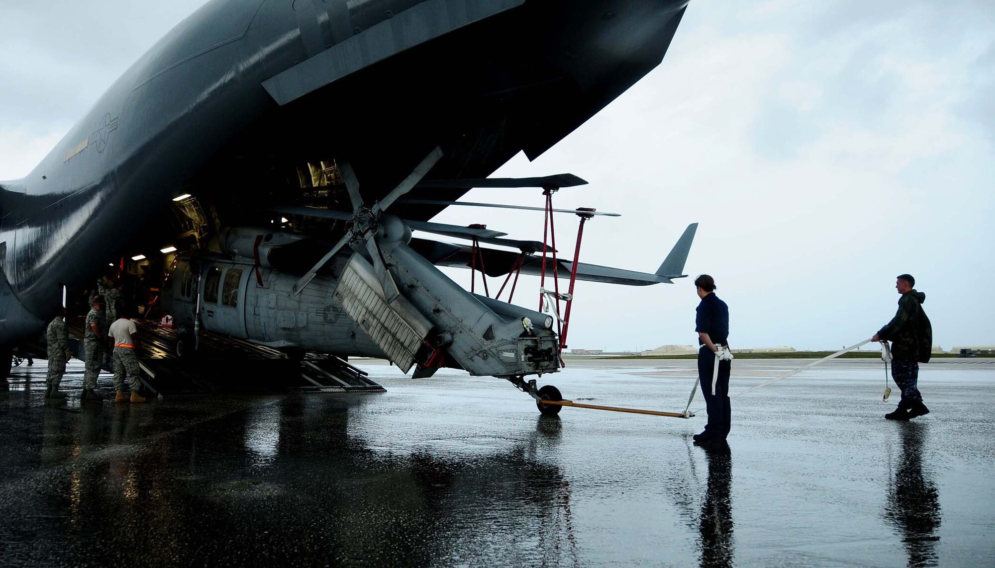 ANDERSEN AIR FORCE BASE, Guam ? Air Force personnel work with Airmen from the Helicopter Sea Combat Squadron 25 to unload two MH-60S Knighthawk from a C-17 Globemaster here June 23, 2010. The aircraft arrived as part of the HSC -25 air asset rotation. The massive undertaking of unloading the two aircraft showcased the team work that is central to Joint Region Marianas.