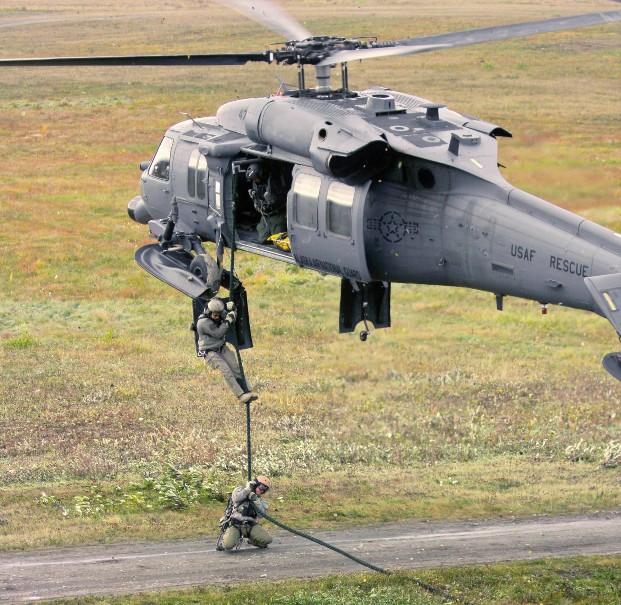 A 210th Rescue Squadron HH-60 Pave Hawk helicopter hovers as pararescuemen from the 212th Rescue Squadron fast rope onto a scene during training June 30, 2010. (U.S. Air Force photo/Master Sgt. Sean Mitchell)