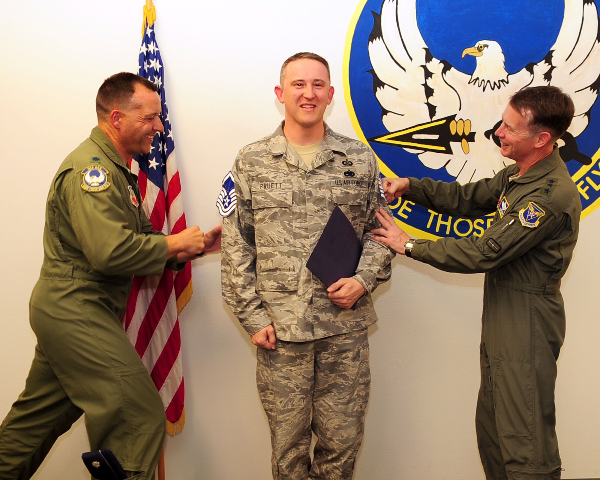 Lt. Gen. Glenn Spears, Twelfth Air Force (Air Forces Southern) commander and Lt. Col. Kevin Blanchard, commander of the 355th Operations Support Squadron, "pin" master sergeant stripes on Master Sgt. Brian Pruett of the 355th OSS, here Jun 29. Sergeant Pruett earned his rank on the spot as a selectee for the Stripes for Exceptional Performers program, which allocates a small handful of stripes to each wing per year. Wing commanders can then use the allocations to promote outstanding individuals to staff sergeant, technical sergeant, and master sergeant. (U.S. Air Force photo/Airman 1st Class Jerilyn Quintanilla)